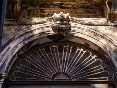 A rendere per� unico il palazzo � un singolare elemento in ferro, ormai arrugginito, che sovrasta la lunetta dell�ingresso. Un triangolo con all�interno il cosiddetto Occhio �di Gadu� o �della Provvidenza�